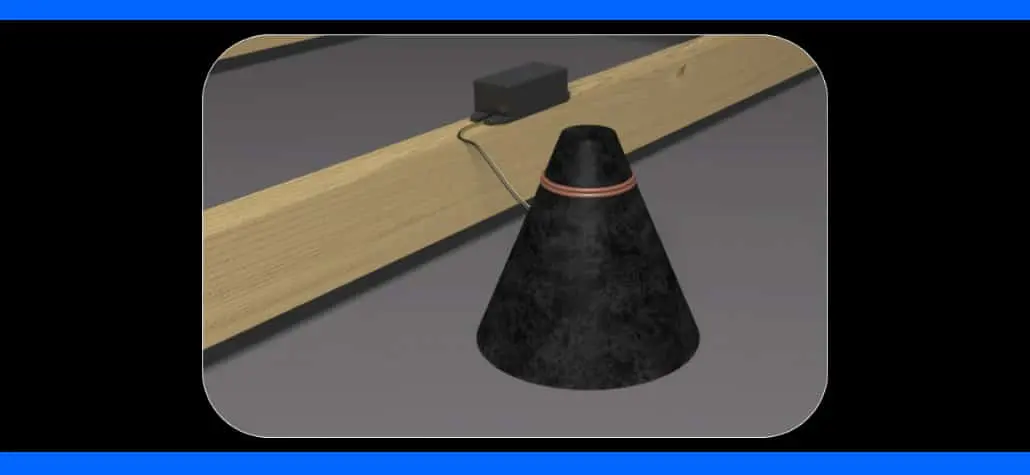 A black cone device on the floor connected to a small black box, placed near wooden beams.