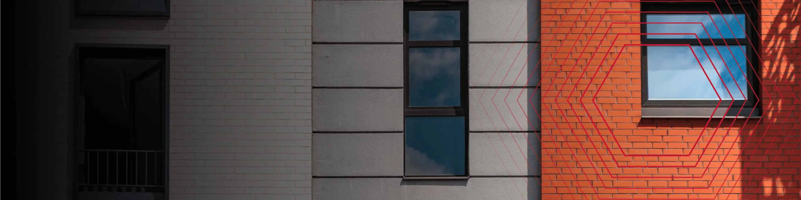 Three building facades in white, gray, and red, each with a single window reflecting the sky.