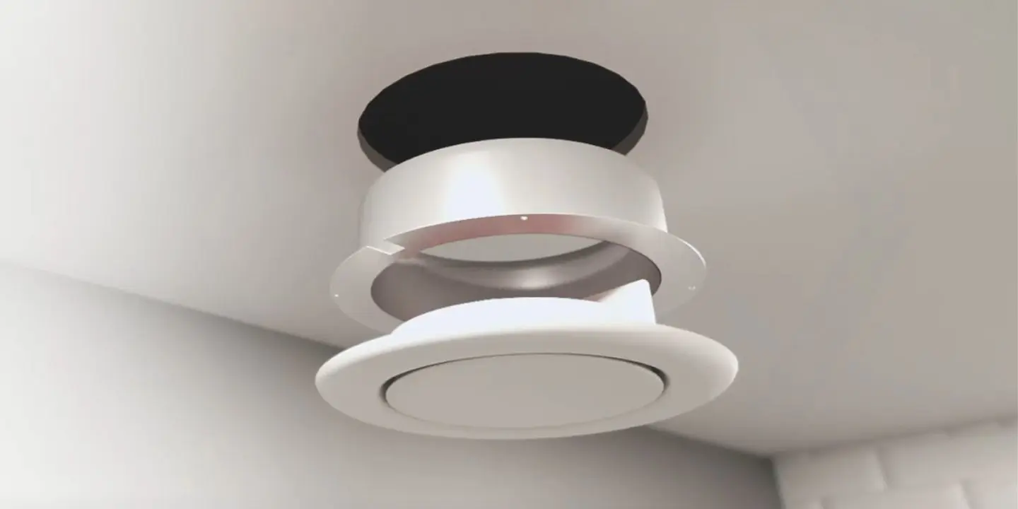 A round ceiling air vent with its cover partially detached, revealing the opening above.