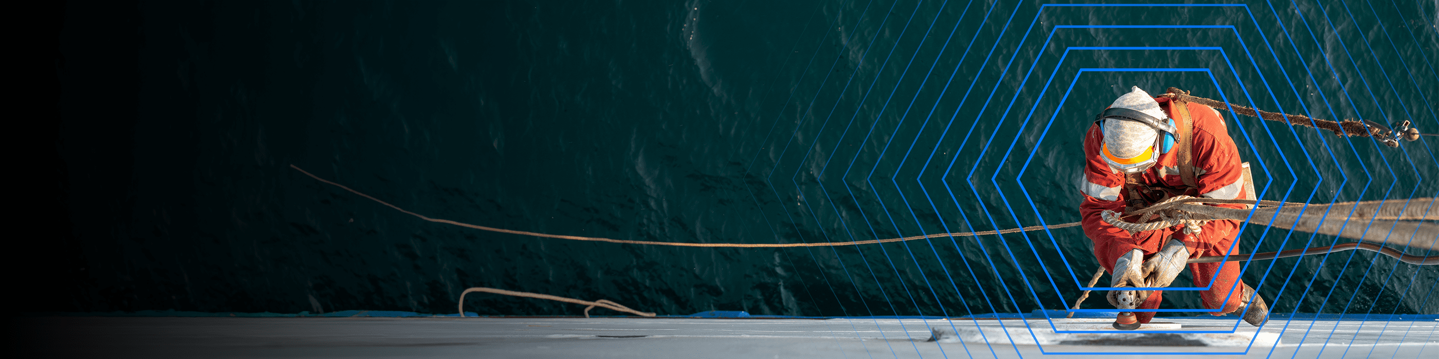 Worker in safety gear handles ropes on a ship deck, with blue hexagonal lines overlayed on the image.