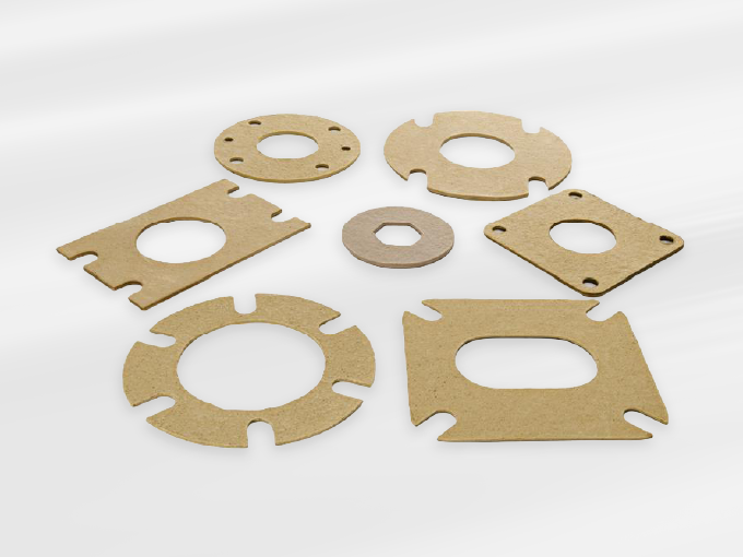 Different shapes and sizes of brown cardboard gaskets arranged on a white background.