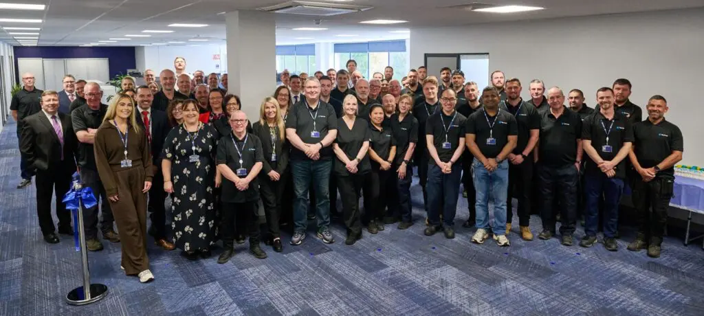 Smiling group poses together in an office.
