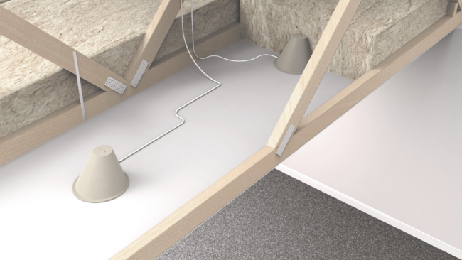 A white cable runs between two cone-shaped devices in an attic with wooden beams and insulation.