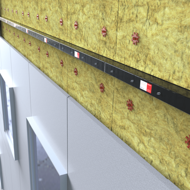 Oct 11 2022 Yellow insulation panels with red fasteners installed on a building wall above gray window frames.