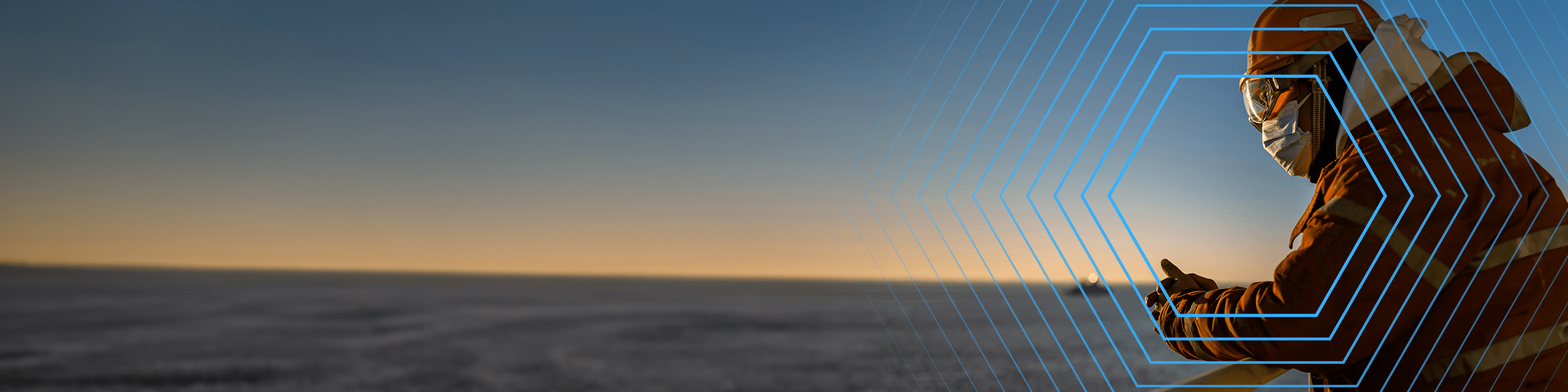 Person in winter gear and goggles stands outdoors at sunrise, hexagonal lines overlay the right side of the image.