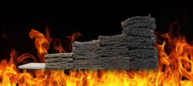 A stack of fire-resistant foam blocks with flames rising in front of them against a black background.