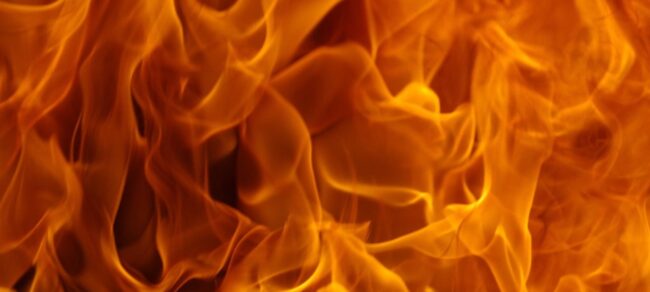 Intense orange and yellow flames swirl together in a vivid fire background.